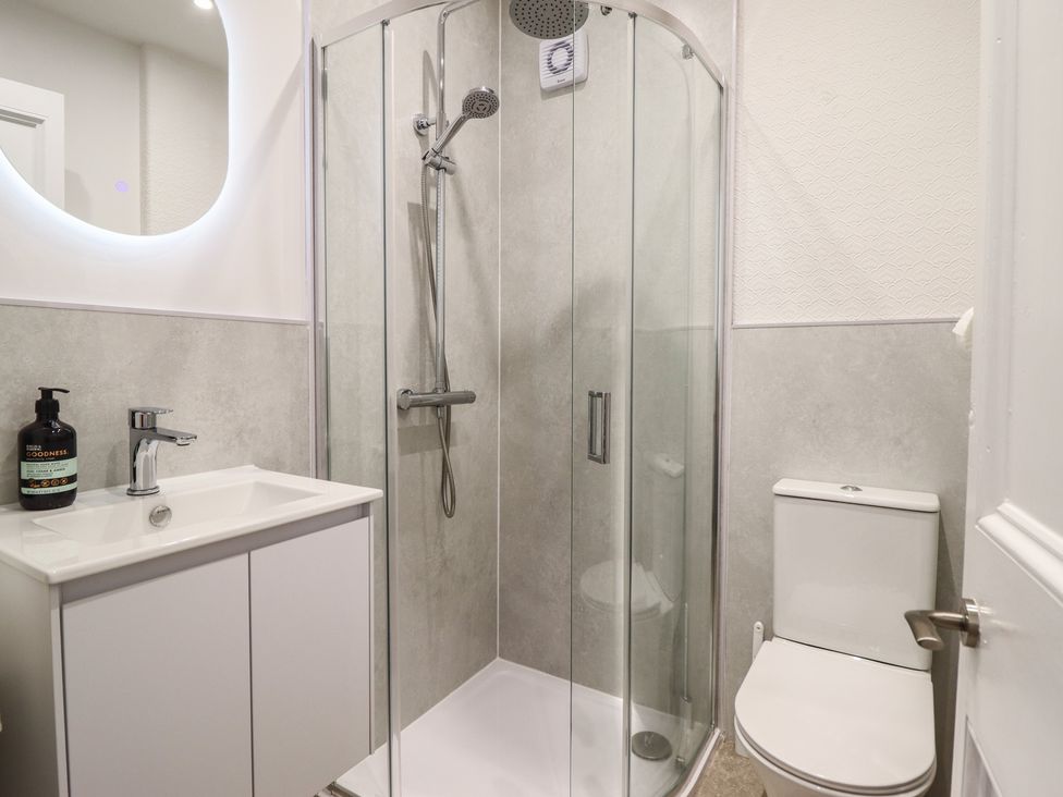A bathroom with a shower, toilet, and sink at Sea View, East Parade in Llandudno