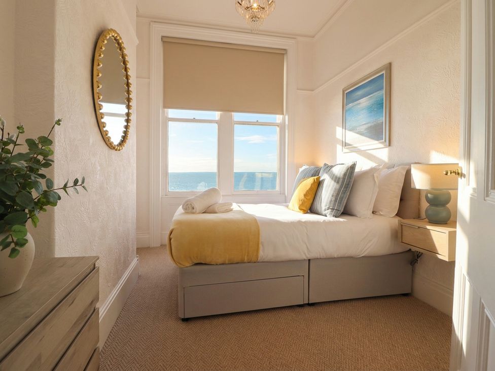 A bedroom with a bed and nightstand at Sea View, East Parade Llandudno