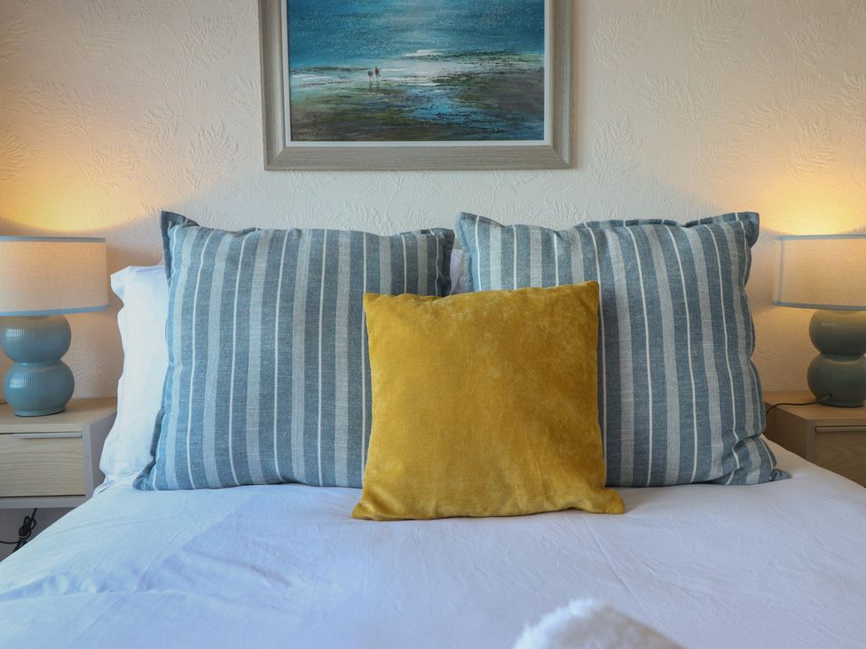 A bedroom with cushions and lamp at Sea View, East Parade in Llandudno