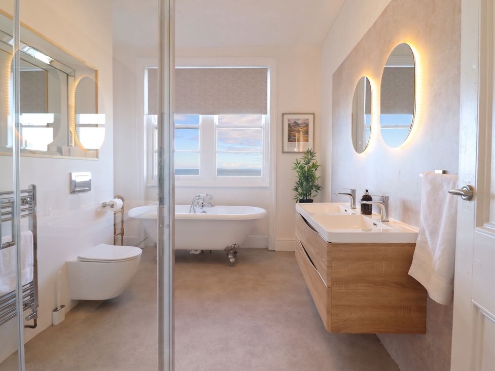 A bathroom with a bathtub and sink at Sea View, East Parade Llandudno