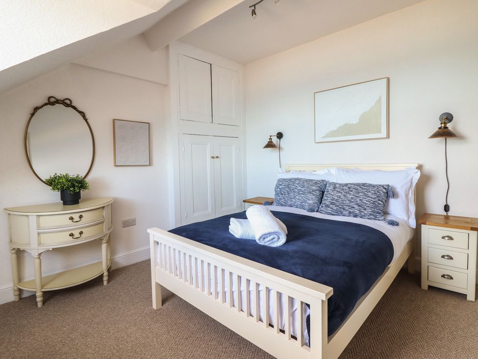 A bedroom with a bed and nightstands at Sea View, East Parade in Llandudno