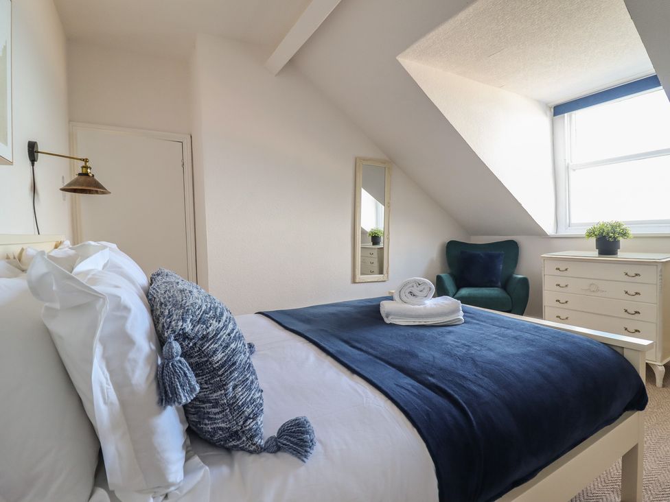 A bedroom with a bed and chair at Sea View, East Parade in Llandudno