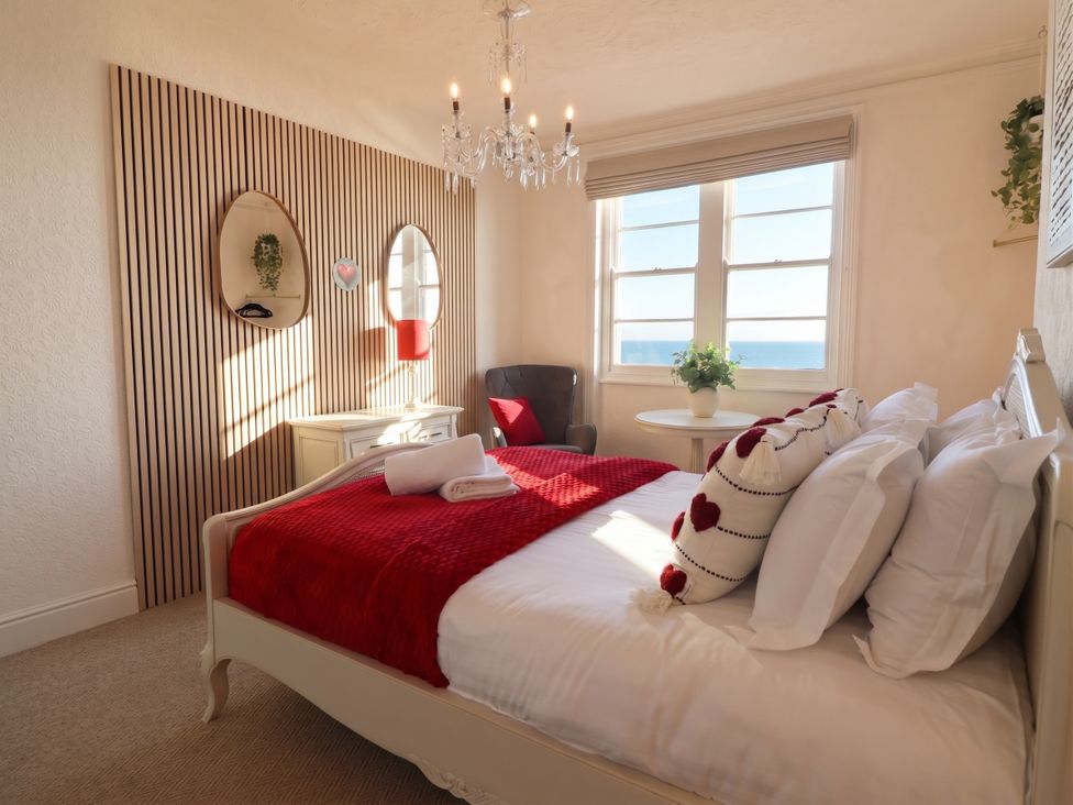 A bedroom with a bed and a chair at Sea View, East Parade Llandudno