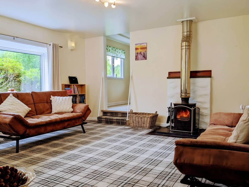 A living room with a fireplace and two sofas at River View Cottage Sleeps 6 - Garden, Bbq, Parking in Pitlochry