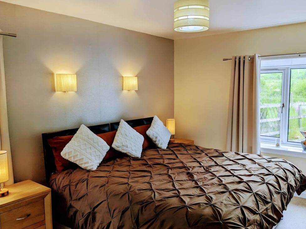 A bedroom with a bed and windows at River View Cottage Sleeps 6 - Garden, Bbq, Parking in Pitlochry