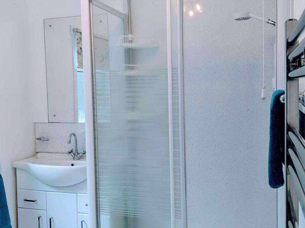 A bathroom with a shower, sink, and mirror at River View Cottage Sleeps 6 - Garden, Bbq, Parking, Pitlochry