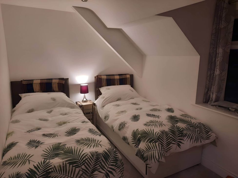 A bedroom with two beds and a bedside table at 3 Bed Barn - Sleeps 6 - Parking - Wifi in Hawkshead