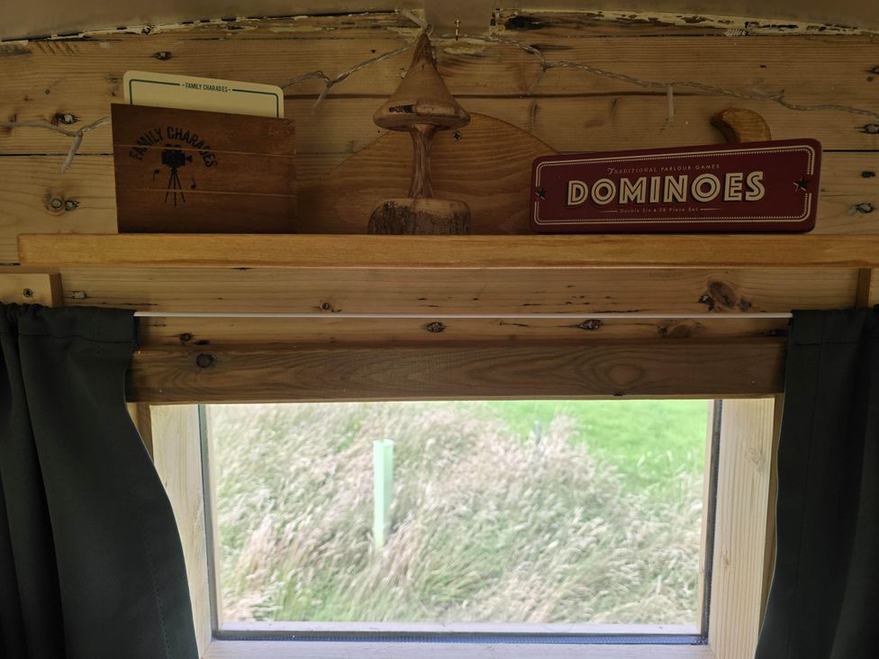 A shelf with a card, a figurine, and a game at Restored circus wagon Saltburn-By-The-Sea