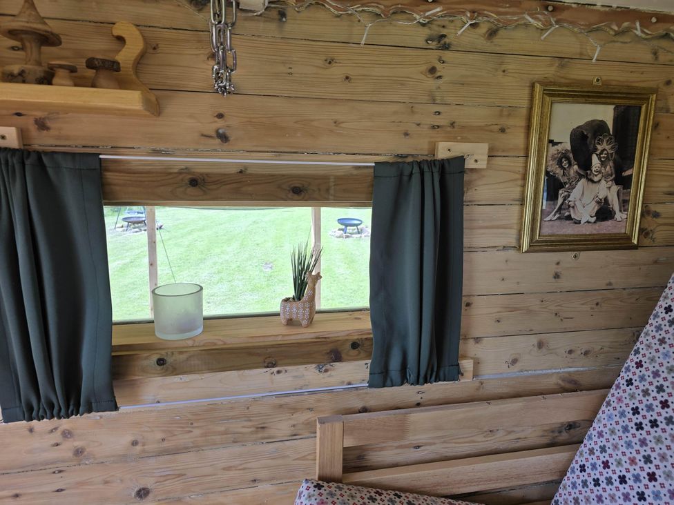 A living room with a window and curtains at Restored circus wagon in Saltburn-By-The-Sea