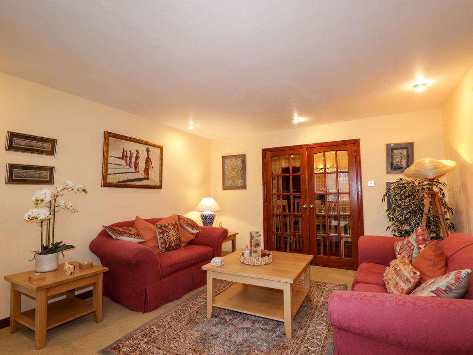 A living room with sofas, a coffee table and a lamp at Dunhallin House in Inverness