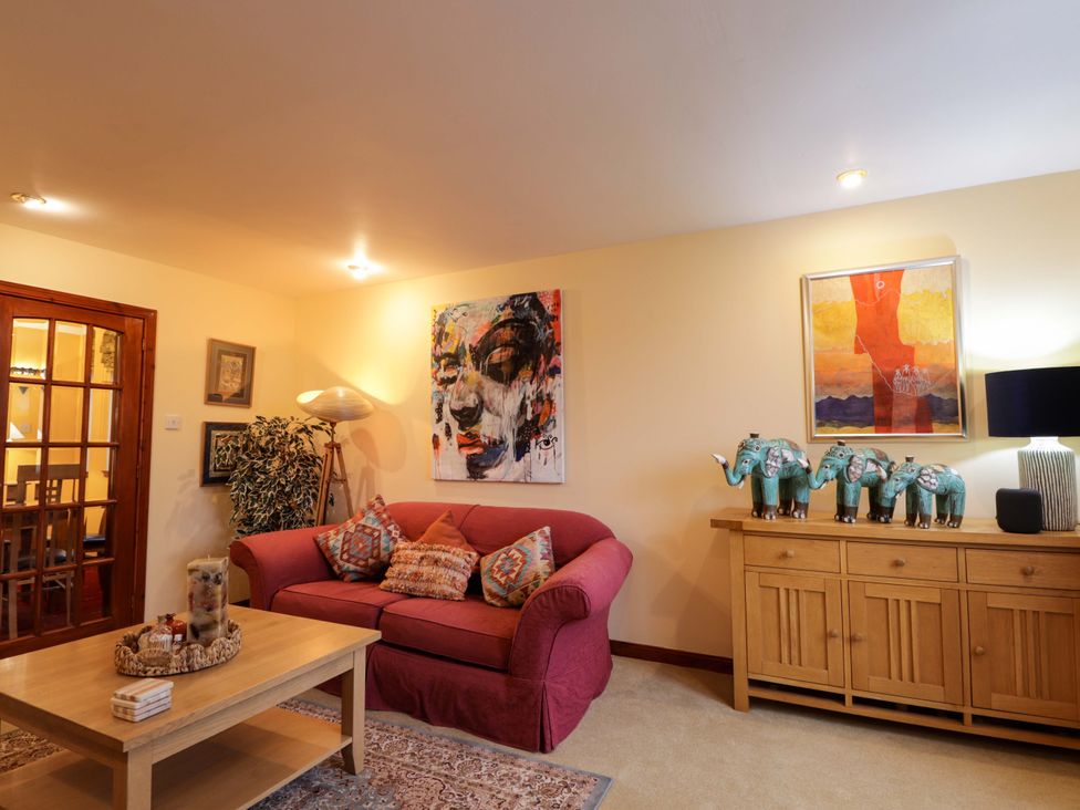 A living room with a sofa and paintings at Dunhallin House in Inverness