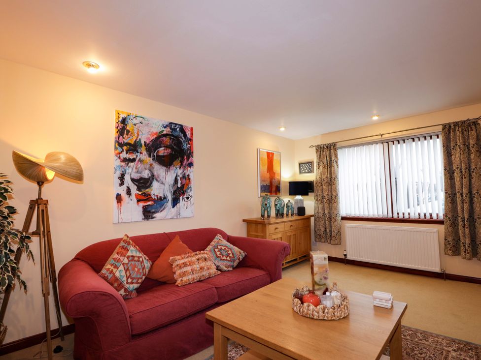 A living room with a sofa and table at Dunhallin House in Inverness