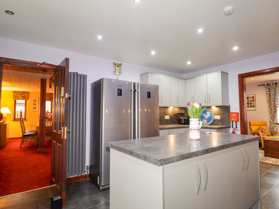 A kitchen with a refrigerator and kitchen island at Dunhallin House in Inverness
