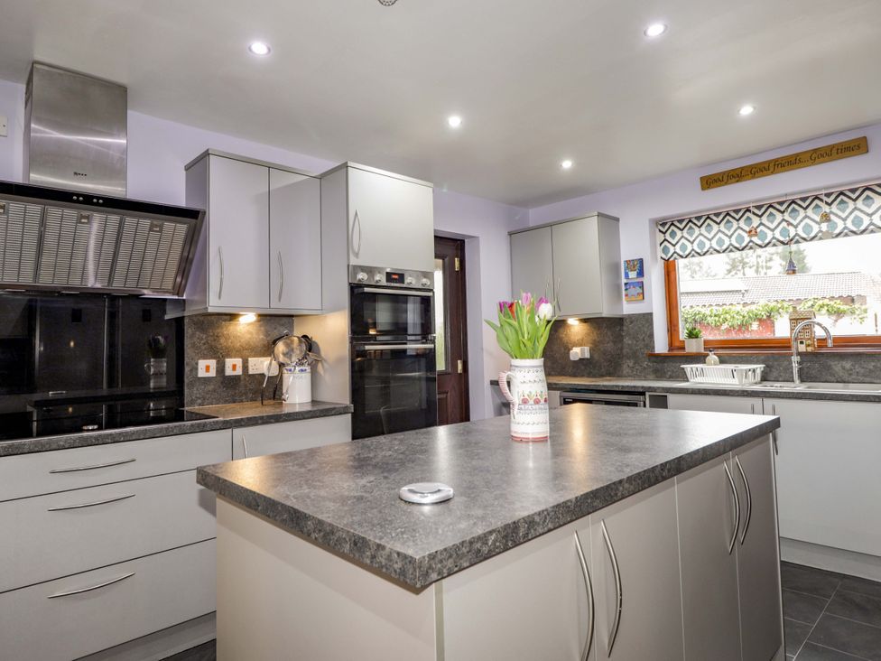 A kitchen with modern appliances and a window at Dunhallin House in Inverness