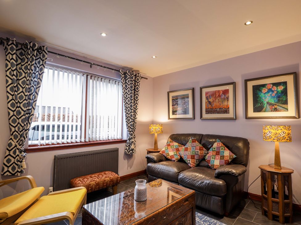 A living room with a sofa and armchair at Dunhallin House in Inverness