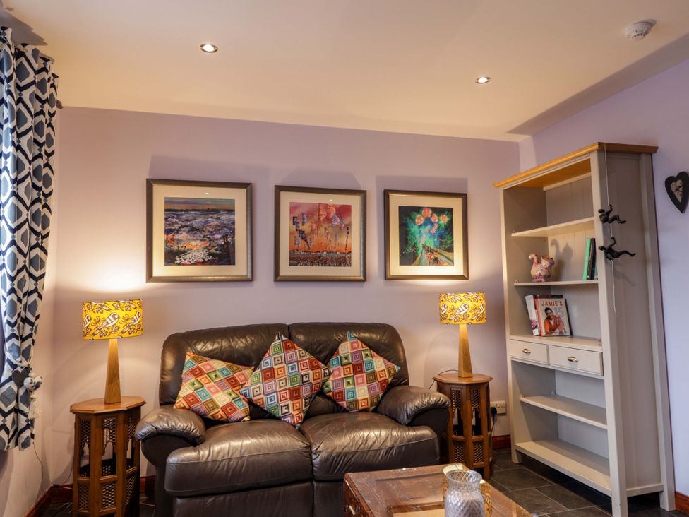 A living room with a sofa and a shelf at Dunhallin House in Inverness