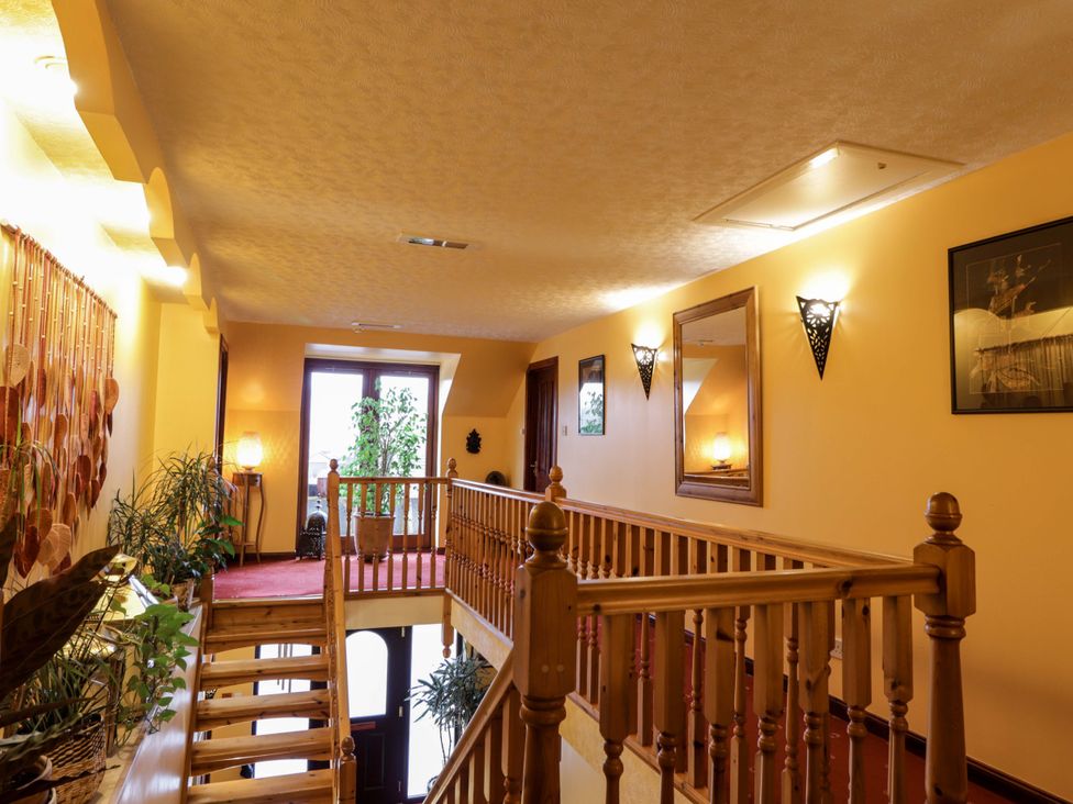A hallway with a staircase and plants at Dunhallin House in Inverness