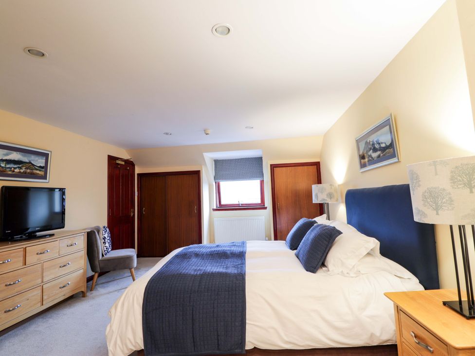 A bedroom with a bed and television at Dunhallin House in Inverness