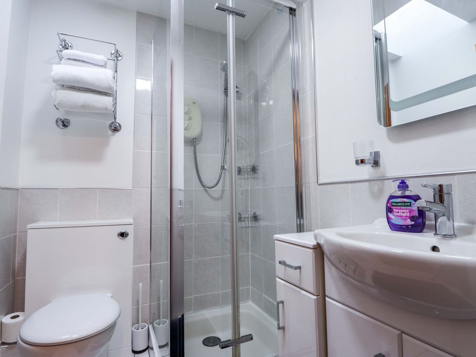 A bathroom featuring a shower, sink, toilet and towels at Dunhallin House in Inverness