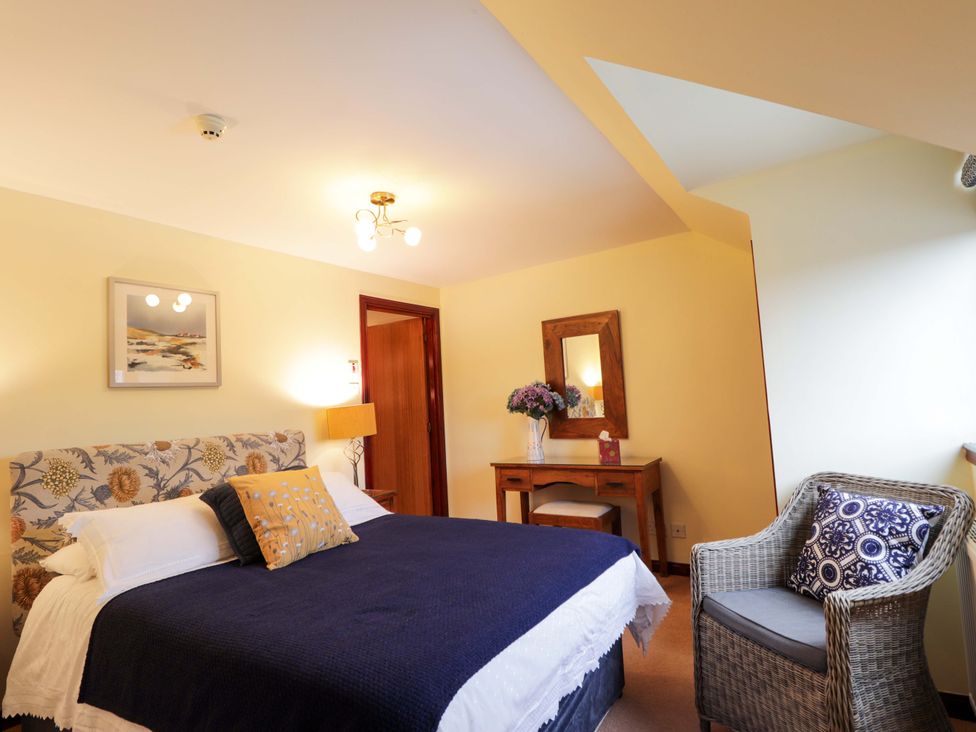 A bedroom with a bed and a table at Dunhallin House in Inverness