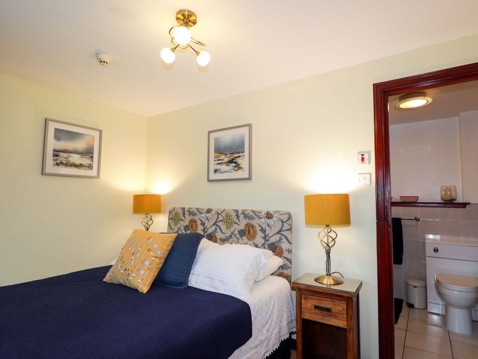 A bedroom with a bed and adjoining bathroom at Dunhallin House in Inverness