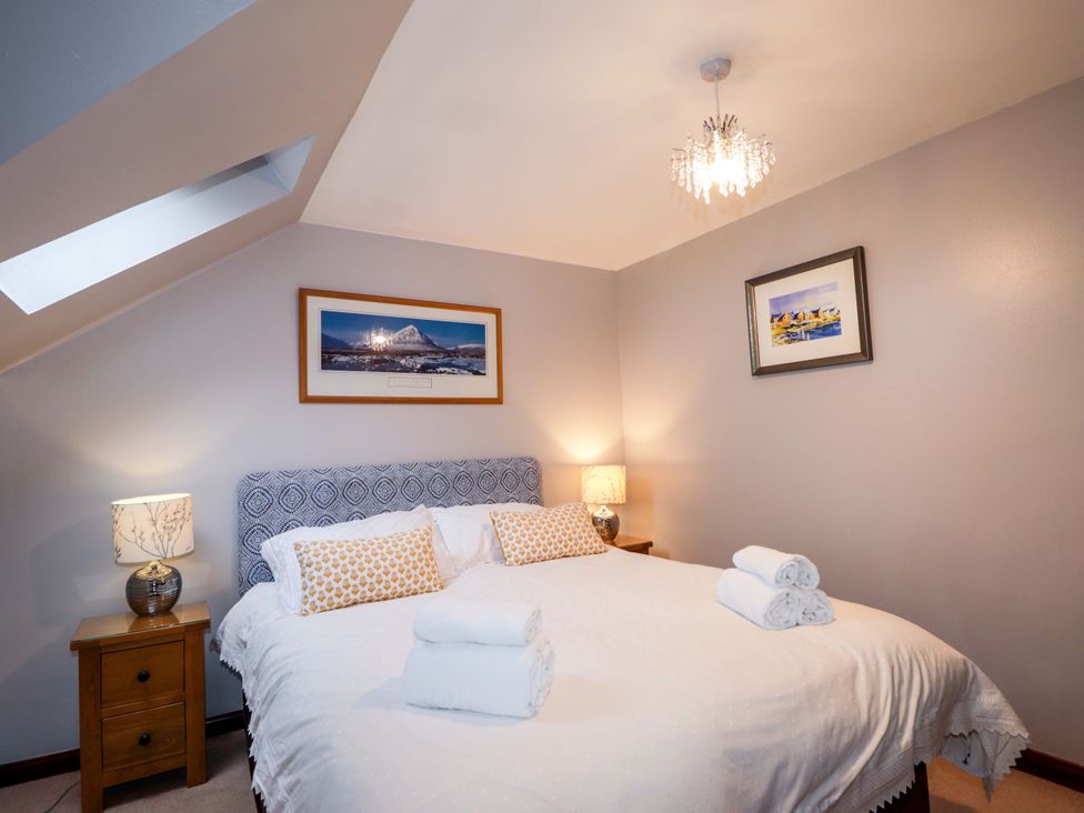 A bedroom with a bed and bedside tables at Dunhallin House in Inverness