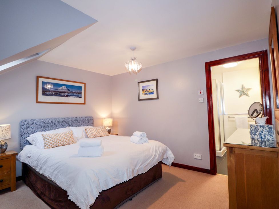 A bedroom with a bed and en-suite bathroom at Dunhallin House in Inverness
