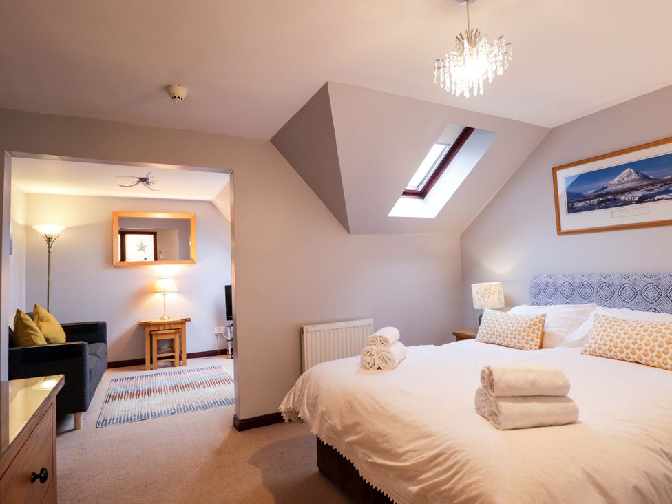 A bedroom with a bed and sofa at Dunhallin House in Inverness