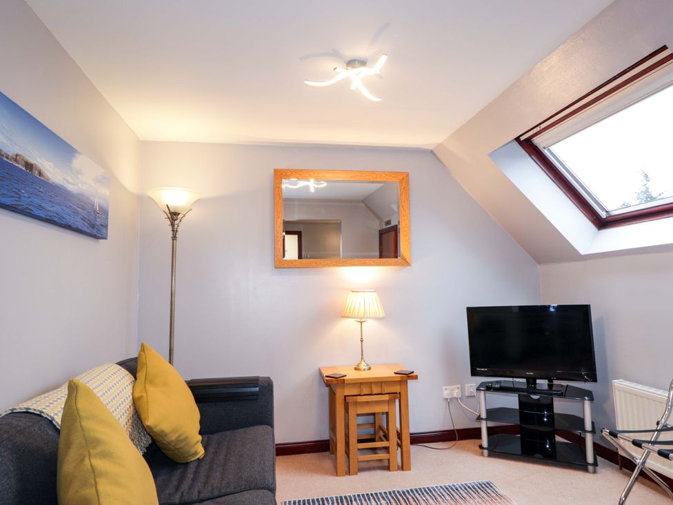 A living room with a couch and a television at Dunhallin House in Inverness