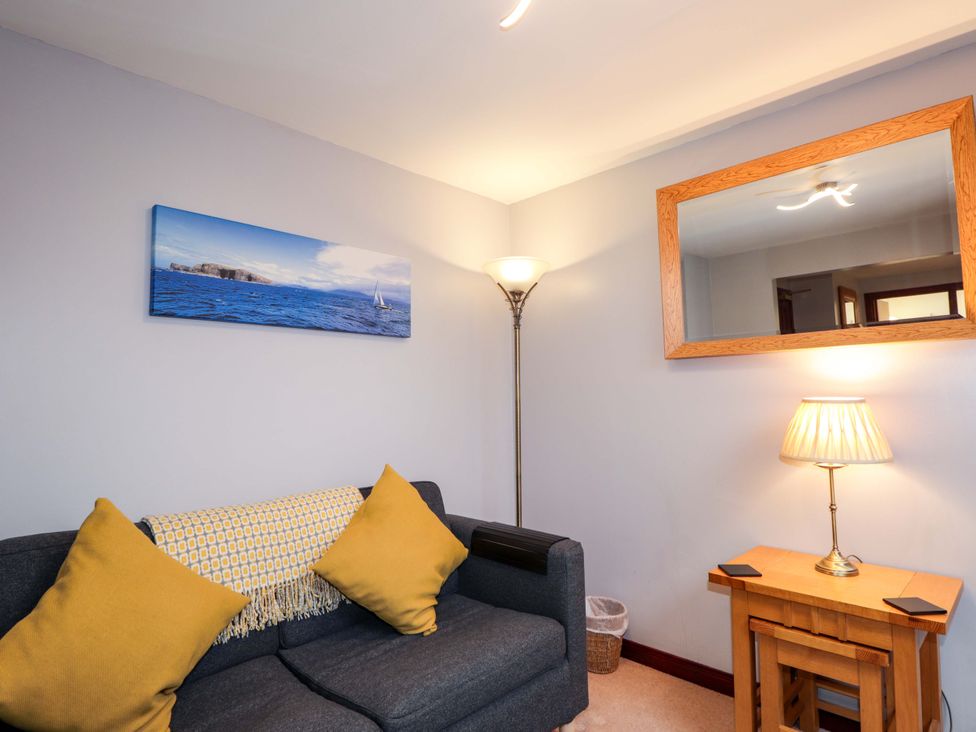 A living room with a sofa and lamp at Dunhallin House in Inverness