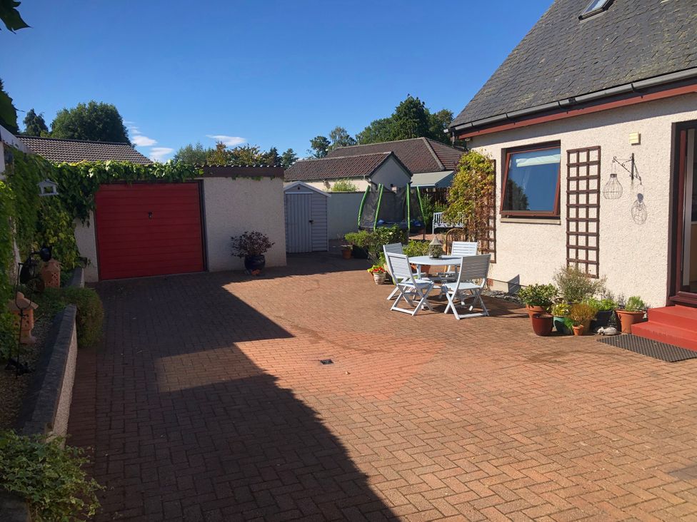 An outdoor area with a table and chairs at Dunhallin House in Inverness