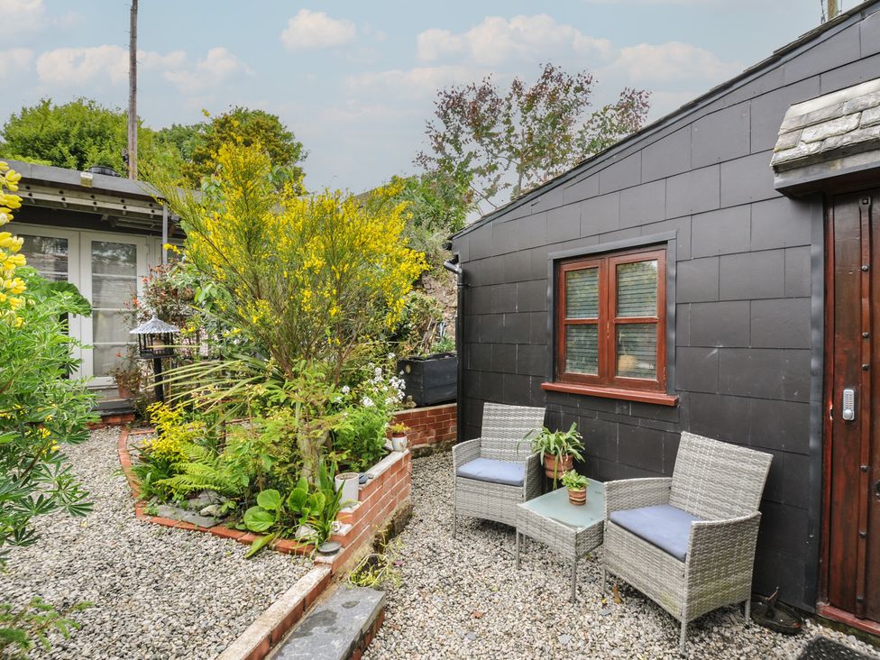 A garden with seating area and plants at Coach House in Camelford
