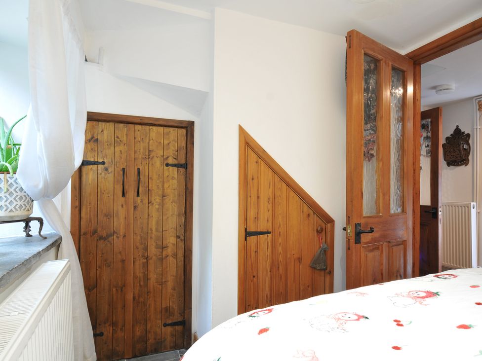 A bedroom with wooden doors and a curtain at Coach House in Camelford