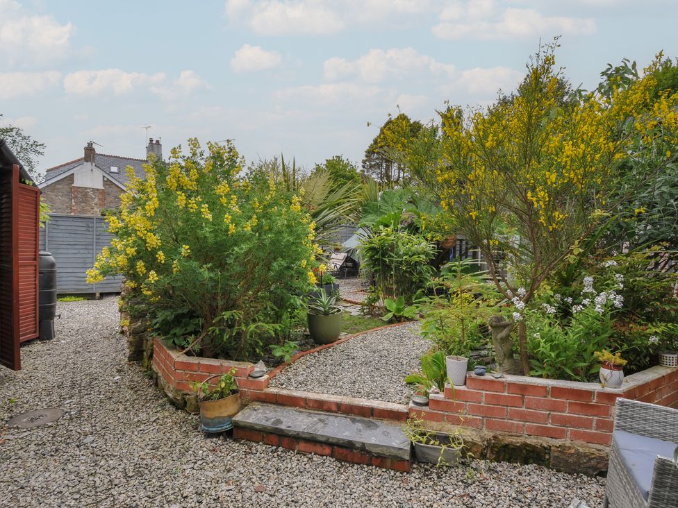 A garden with plants and gravel pathway at Coach House Camelford