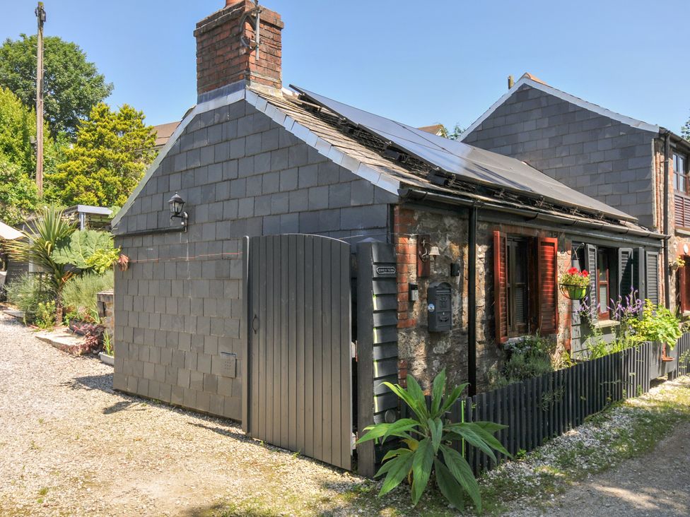 An exterior view of a house with solar panels and a gate at Coach House in Camelford