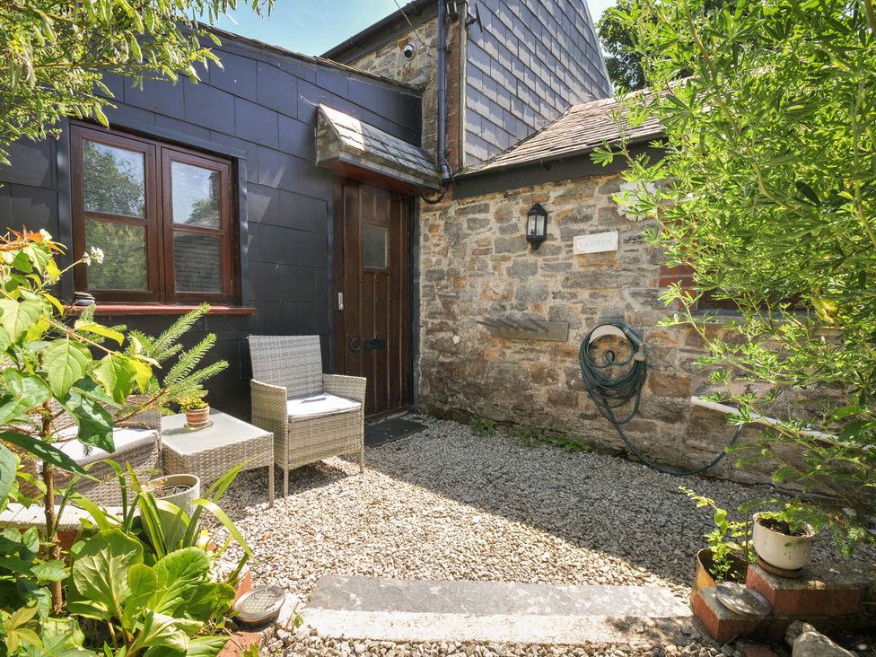 An outdoor area with chairs and a table at Coach House in Camelford