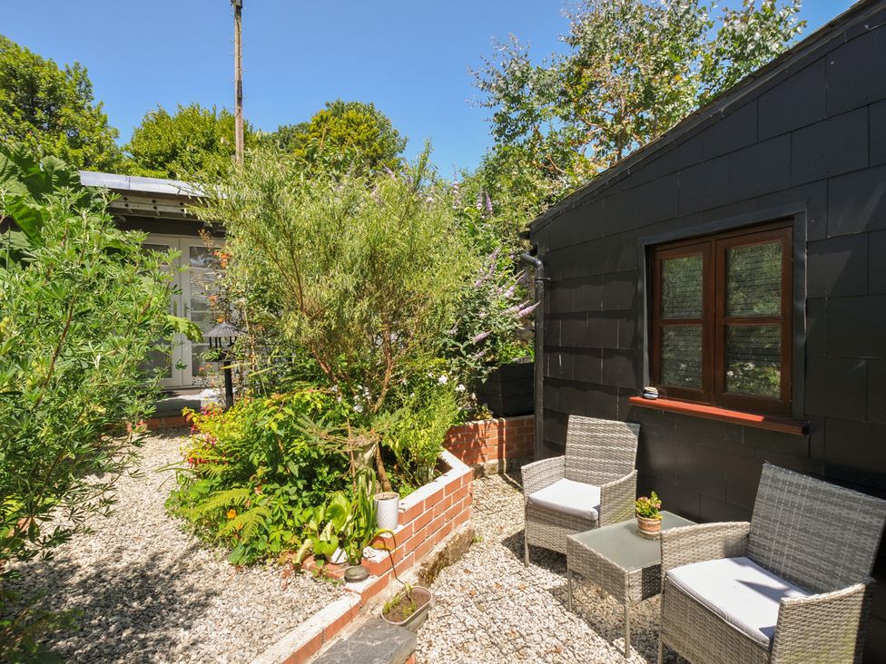 A garden with chairs and plants at Coach House in Camelford
