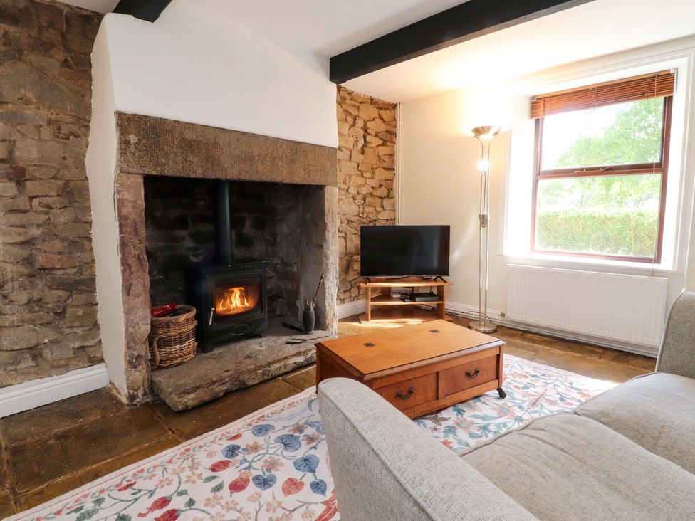 A living room with a fireplace and television at 6 Hazel Moor Blackburn
