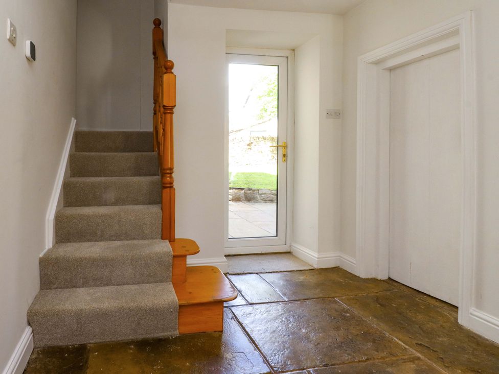 A hallway with a staircase and front door at 6 Hazel Moor Blackburn