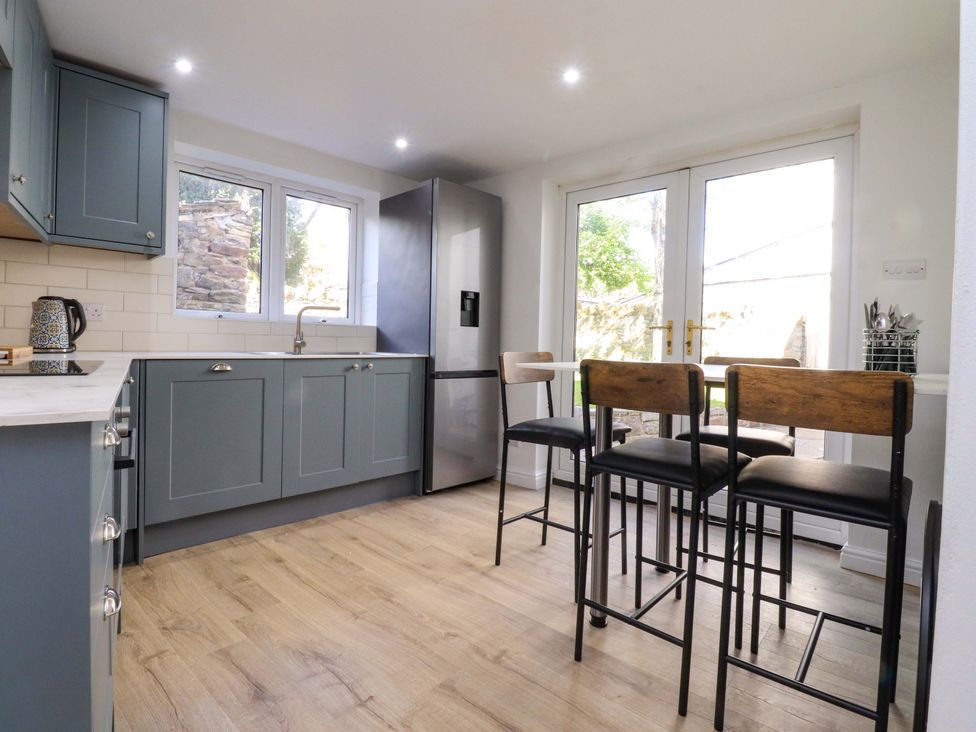 A kitchen with cabinets and a refrigerator at 6 Hazel Moor Blackburn