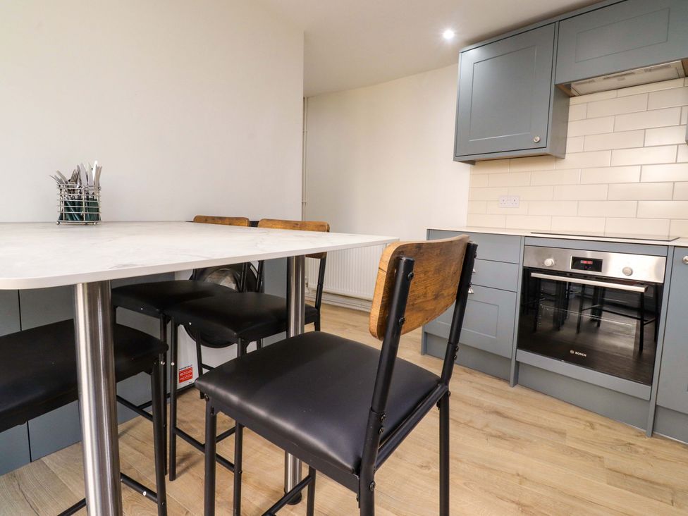 A kitchen with a table and stools at 6 Hazel Moor in Blackburn