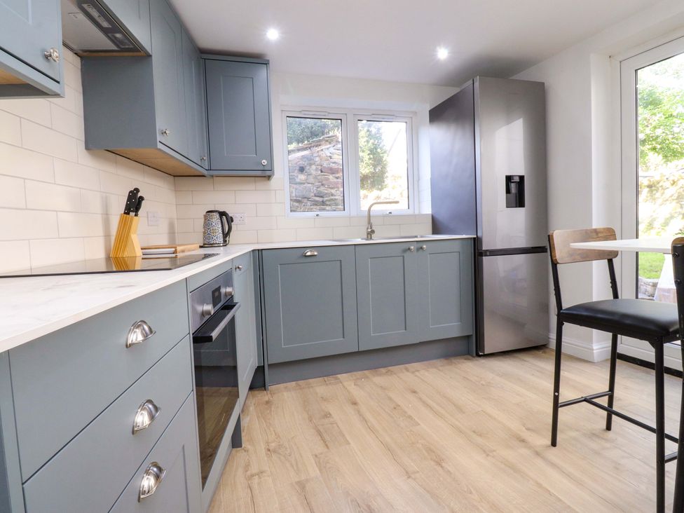 A kitchen with cabinets, sink, fridge and a stool at 6 Hazel Moor Blackburn