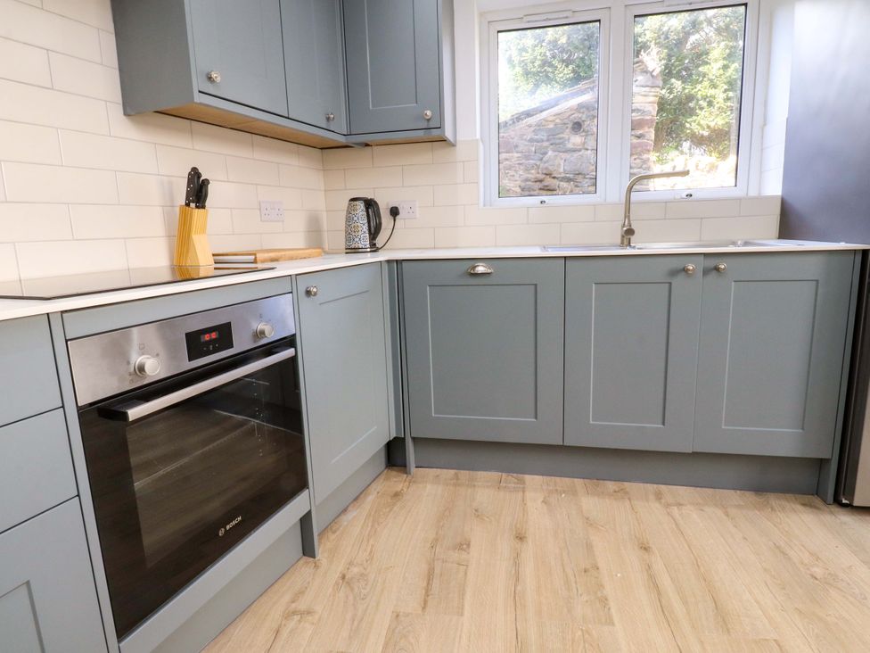 A kitchen with cabinets, an oven, and a sink at 6 Hazel Moor Blackburn