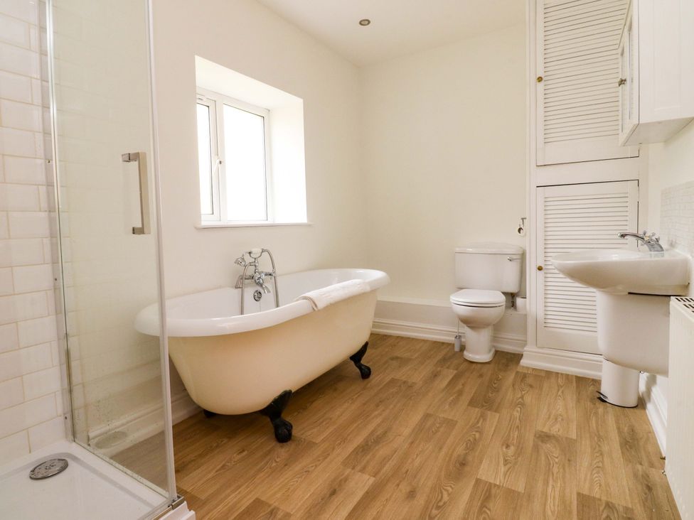 A bathroom with a bathtub, toilet, sink, and shower at 6 Hazel Moor Blackburn