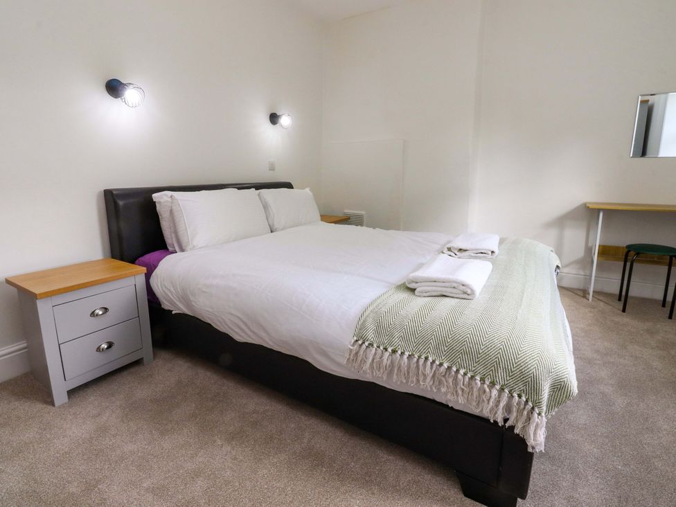 A bedroom with a bed and nightstand at 6 Hazel Moor Blackburn