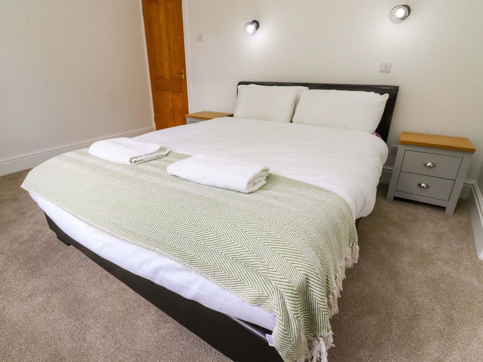 A bedroom with a bed and nightstand at 6 Hazel Moor Blackburn