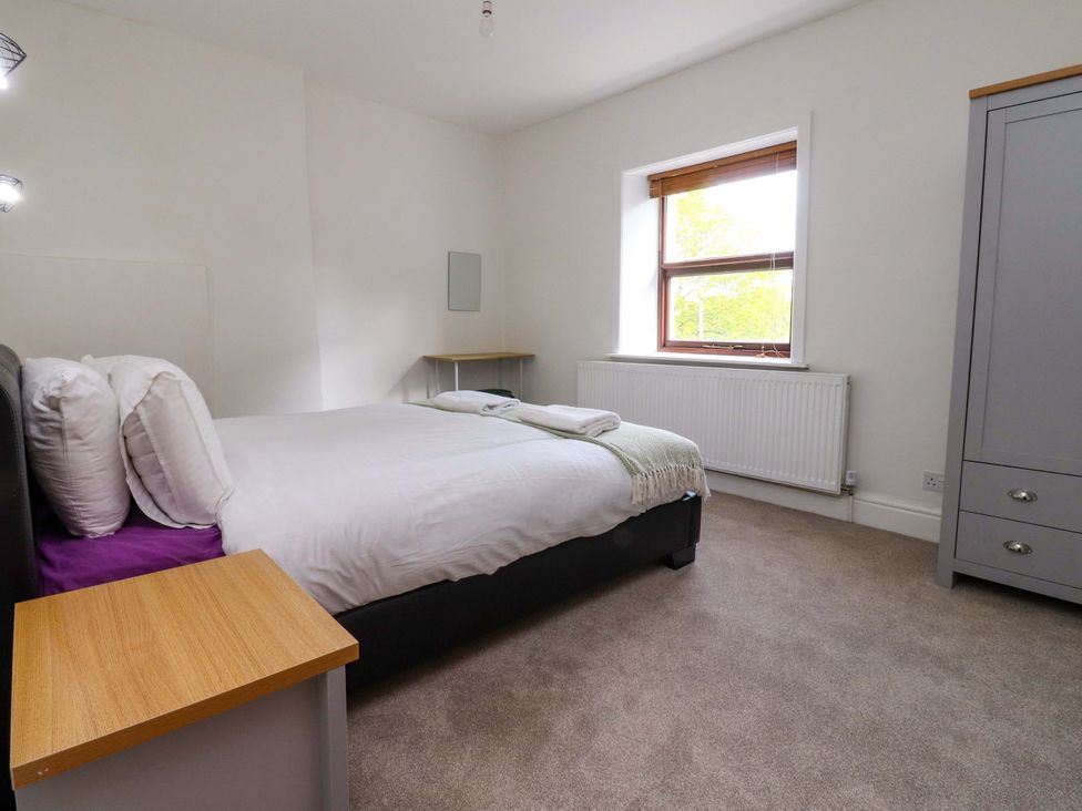 A bedroom with a bed and a wardrobe at 6 Hazel Moor in Blackburn