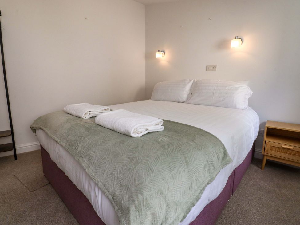 A bedroom with a bed and towels at 6 Hazel Moor Blackburn