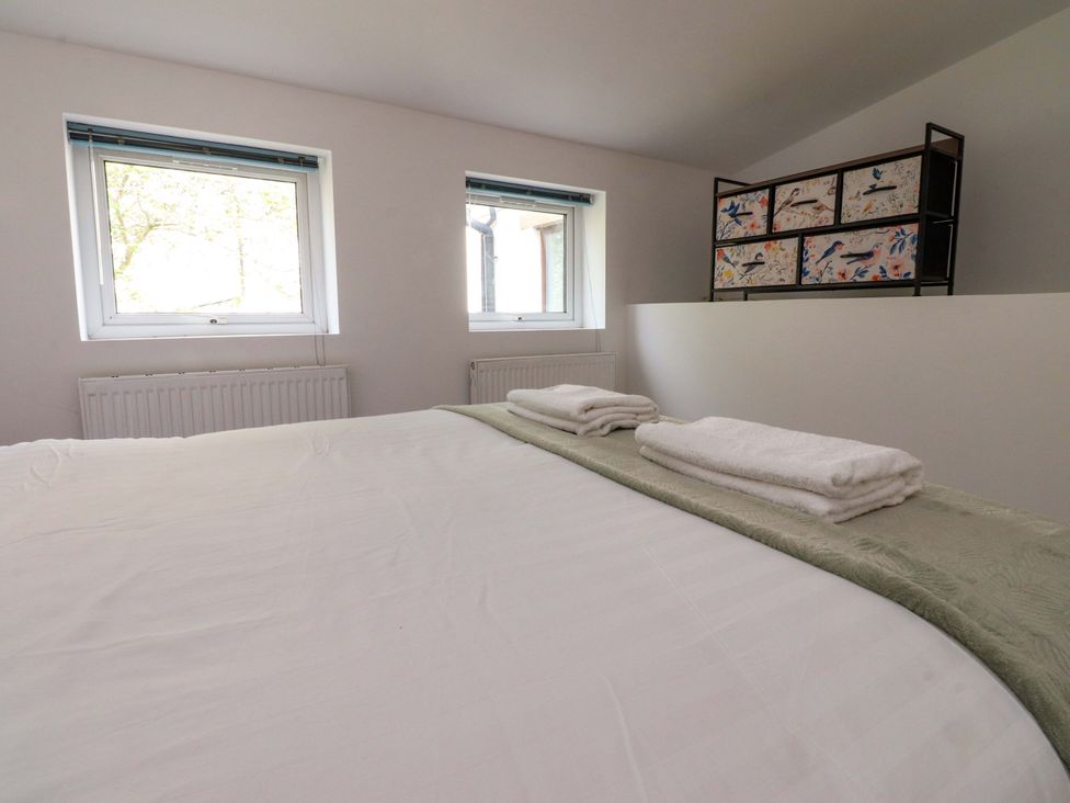 A bedroom with a bed and windows at 6 Hazel Moor Blackburn