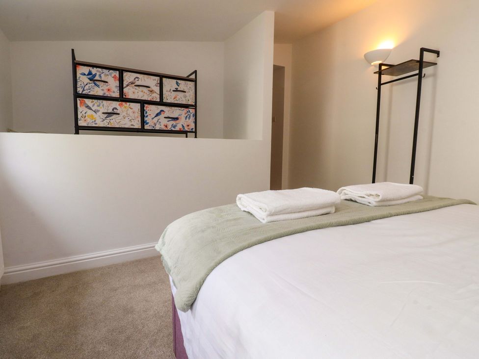 A bedroom with a bed and decorative cabinet at 6 Hazel Moor Blackburn